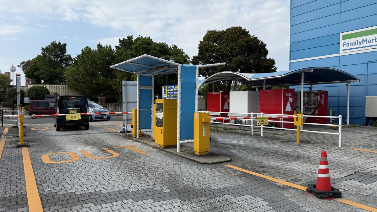 第二駐車場の出口(出庫ゲート)です。入口と出口が隣接しており、奥にコンビニ(ファミリーマート)の看板も見えます。