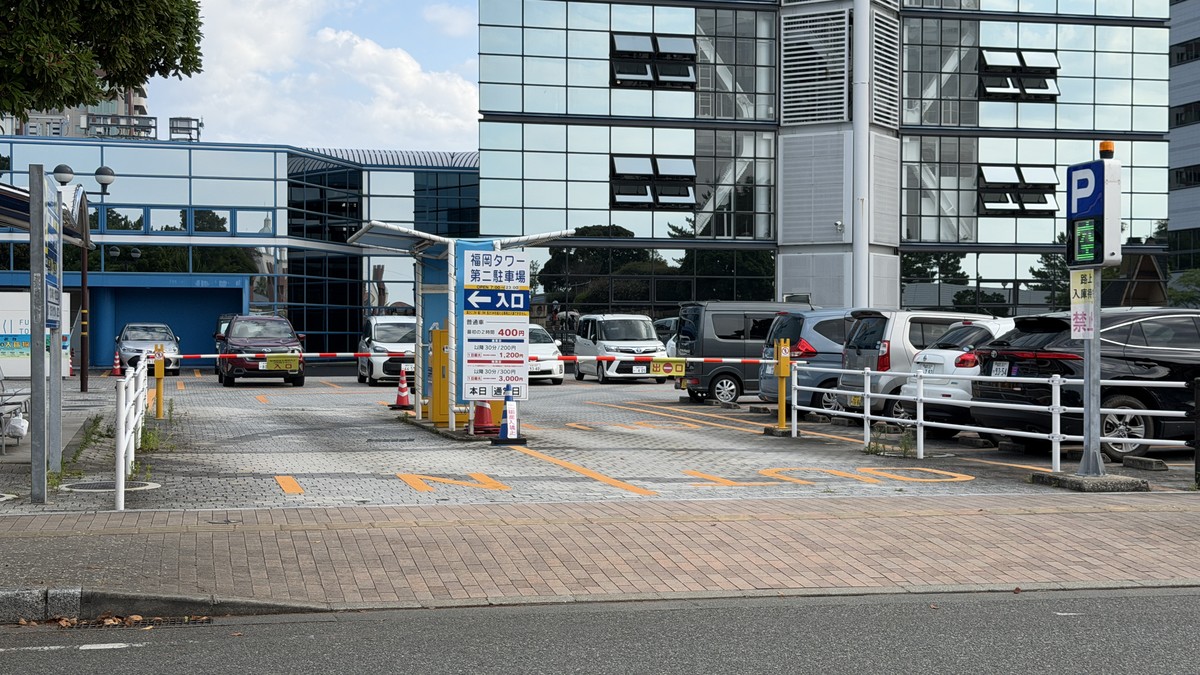 第二駐車場の出入口全体です。案内看板には「本日:通常日」など、その日の料金区分を示す表示があります。右手には満車・空車を知らせる案内灯も設置されています。